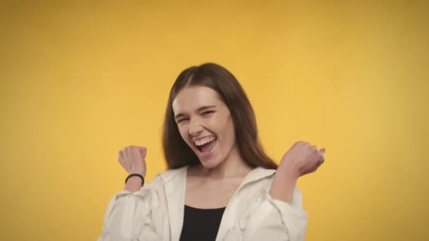 Jong volwassen Kaukasische vrouw viert een prestatie op een heldere gele achtergrond — Stockvideo