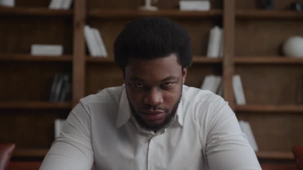 Jovem adulto empresário afro-americano levantando a cabeça e olhando para a câmera enquanto sorri — Vídeo de Stock