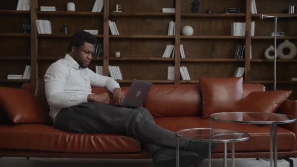 Junger erwachsener afrikanisch-amerikanischer Unternehmer bei einer Telefonkonferenz auf seinem Laptop — Stockvideo