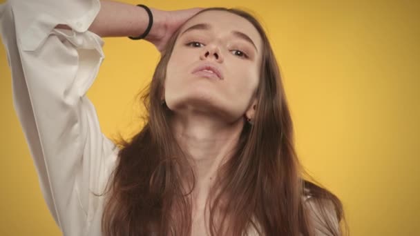 Joven mujer caucásica adulta posando en cámara lenta sobre un fondo amarillo brillante — Vídeos de Stock