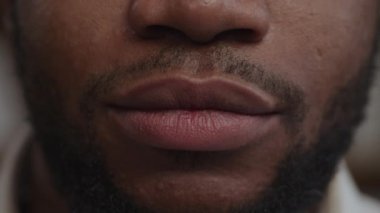 Yetişkin bir Afro-Amerikalı adamın yakın çekim gülümsemesi.