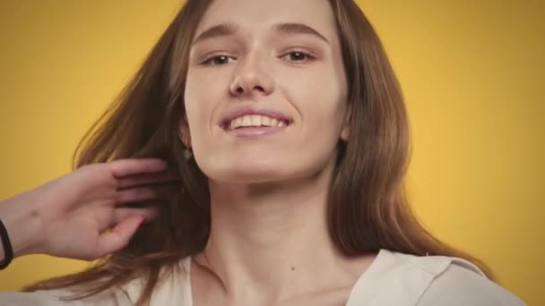 Jovem mulher caucasiana adulta está posando em um fundo amarelo brilhante no estúdio — Vídeo de Stock