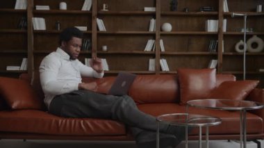 Genç Afro-Amerikan girişimci dizüstü bilgisayarında konferans görüşmesi yapıyor.