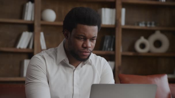 Close-up van een volwassen zakenman die in zijn kantoor aan een laptop werkt — Stockvideo