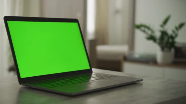 Kameraschwenk über einen Laptop mit grünem Bildschirm in der Wohnung — Stockvideo