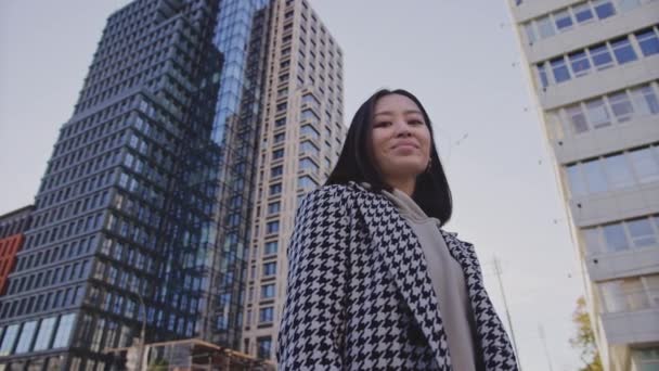 Portret van een zakenvrouw onder een hoogbouw in de stad — Stockvideo
