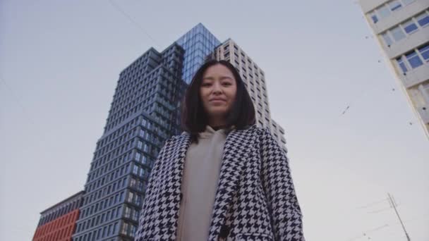 Basso angolo ritratto di una giovane donna asiatica adulta nel centro del distretto — Video Stock
