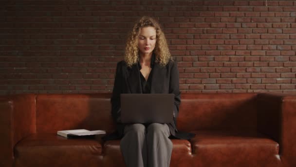 Junge erwachsene Geschäftsfrau arbeitet in einer Dachgeschosswohnung an einem Laptop — Stockvideo