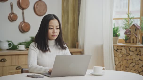 Mujer joven de 20 años en busca de una solución frente a su computadora portátil en el interior — Vídeo de stock