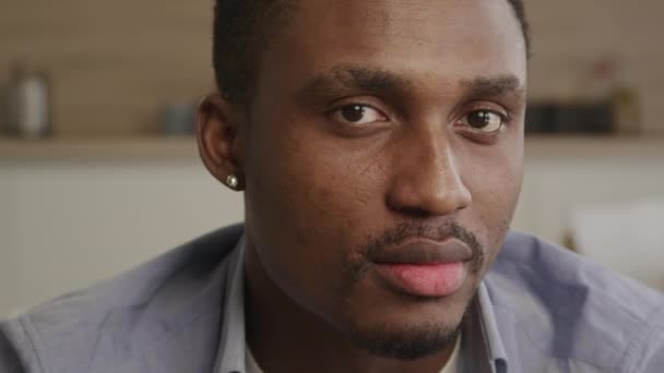 Közelkép egy fiatal afro-amerikai férfi arcképéről, aki egyenesen a kamerába néz. — Stock videók