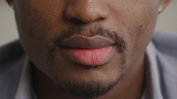 Молодий дорослий чоловік заспокоює губи крупним планом — стокове відео