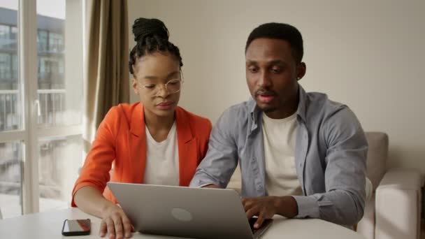Junge Familie erhält gute Nachrichten in ihrer Wohnung vor dem Laptop — Stockvideo