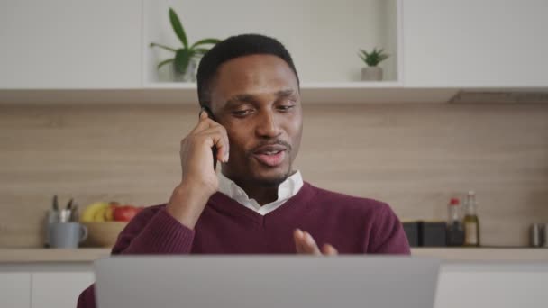 Nahaufnahme eines jungen erwachsenen Geschäftsmannes, der vor seinem Laptop telefoniert — Stockvideo