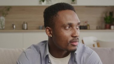 Yetişkin bir Afro-Amerikan 'ın yan bakan portresini yakından çek ve kameraya doğru dön ve gülümse.