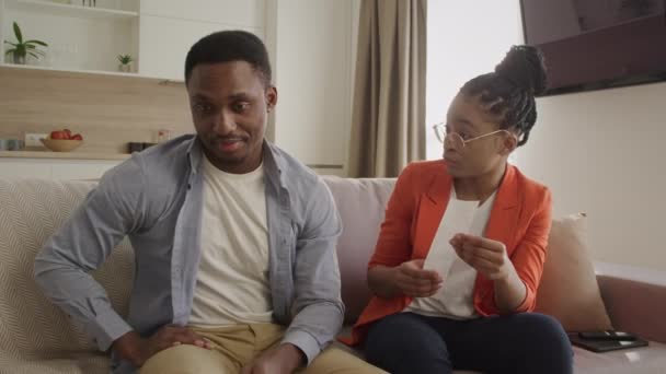 Junges afrikanisches Paar verwaltet seine Ausgaben im Wohnzimmer — Stockvideo