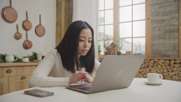 Mujer joven leyendo un mensaje positivo en su portátil en su apartamento — Vídeos de Stock