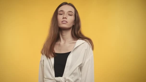 Jovem mulher caucasiana adulta posando em um fundo amarelo brilhante — Vídeo de Stock
