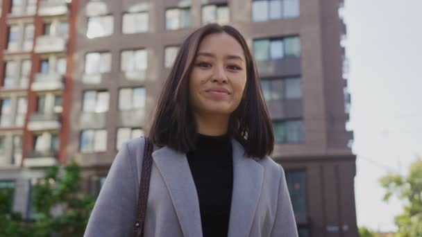 Portret van een jonge lachende Aziatische vrouw in de steet van de stad — Stockvideo