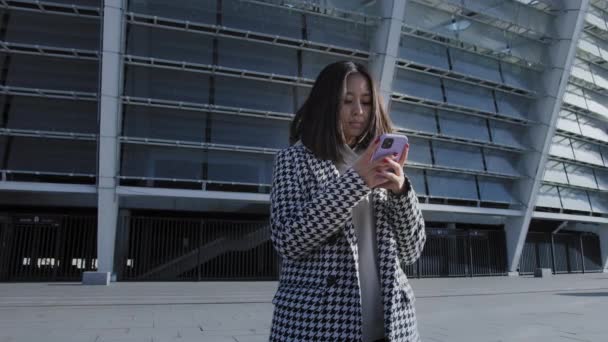 Mladá dospělá žena psaní na její smartphone v centru města — Stock video