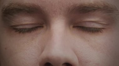 Yakın plan beyaz adam mavi gözlerini yavaş çekimde açıyor.