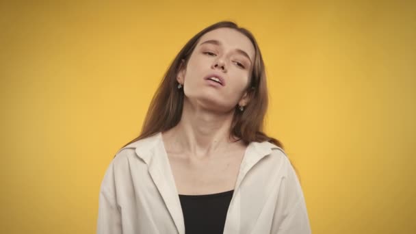 Fiatal felnőtt kaukázusi nő boldogtalan egy fényes sárga háttér — Stock videók