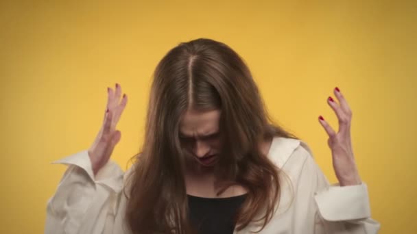 Young adult caucasian woman is feeling anxious on a bright yellow background in studio — Stock Video