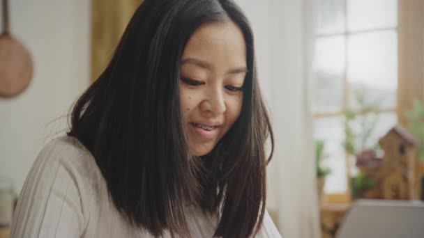 Smiling asian woman portrait with braces while working on her laptop in slow motion — ストック動画