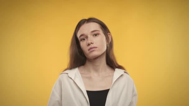 Jovem mulher caucasiana adulta está posando em um fundo amarelo brilhante — Vídeo de Stock
