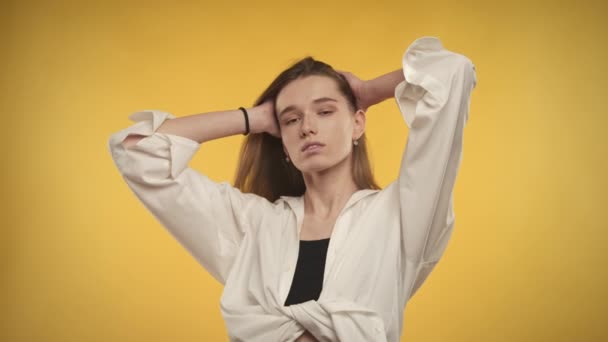 Jeune femme caucasienne adulte frappe une pose sur un fond jaune vif — Video
