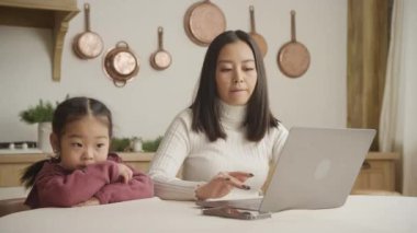 Heyecanlı anne-kız internette bilgisayarda geziniyor ve konuşuyorlar.