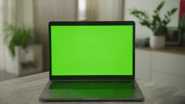 Statisk bild av en bärbar dator med en grön skärm på ett skrivbord i modern lägenhet — Stockvideo