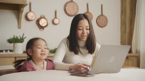 Young mother and daughter talking in front of a laptop indoors — Stock videók