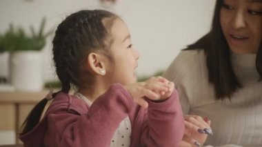 Close up of a young girl talking to her mother at home