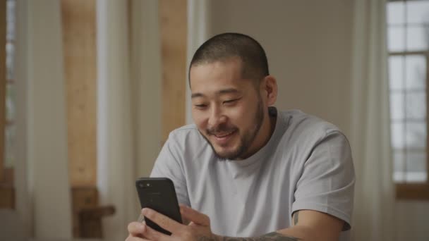 Junge erwachsene asiatische Mann auf einer Videokonferenz Anruf auf seinem Smartphone — Stockvideo