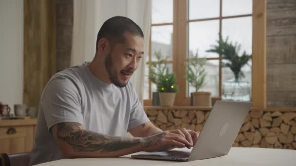 Junger erwachsener glücklicher Unternehmer tippt vor Freude auf seinem Laptop — Stockvideo