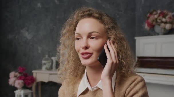 Zbliżenie na młodą białą kobietę nieśmiałą rozmawiającą przez telefon — Wideo stockowe