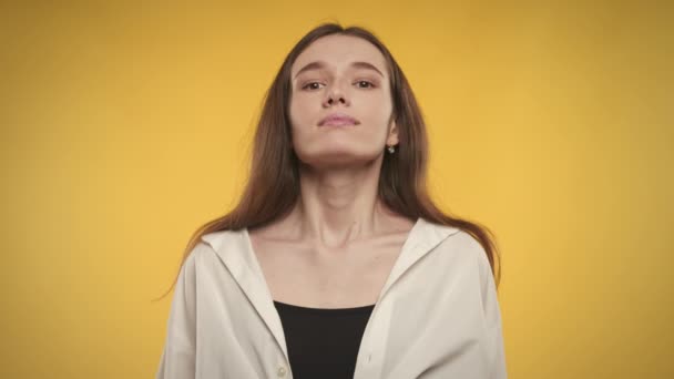 Женщина делает глубокий вдох и выдыхает на ярко-желтом фоне — стоковое видео