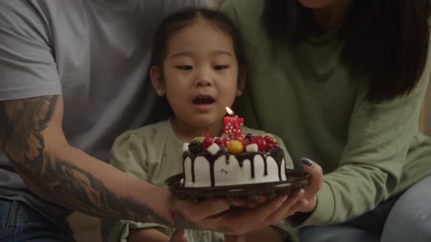 Menina soprando velas em um bolo de aniversário celebrando 5 anos — Vídeo de Stock