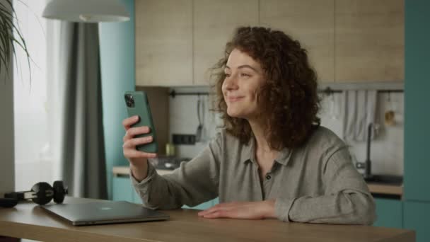 Jong twintiger jaren volwassen student met een video conference call op haar smartphone — Stockvideo
