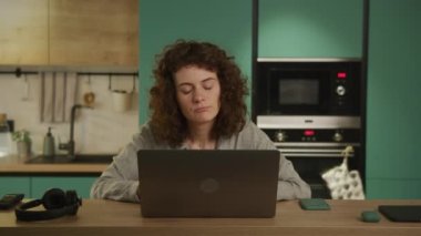 20 'li yaşlarda genç bir öğrenci laptopundan üzücü haberler okuyor.