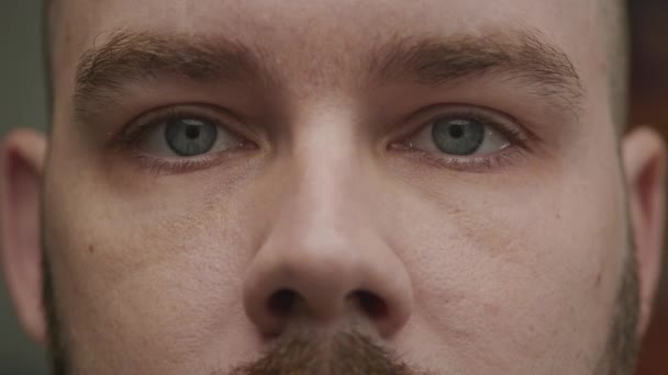 Gros plan d'un jeune homme caucasien adulte ouvrant ses yeux bleus au ralenti — Video
