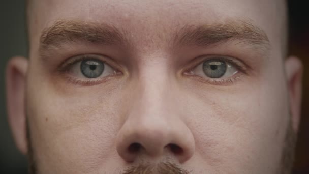 Close-up de um branco masculino olhos azuis batendo uma sobrancelha — Vídeo de Stock