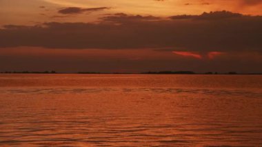 Yaz nehri manzarasında gün batımının altın yansımaları ağır çekimde