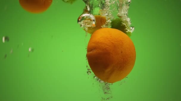 이국적 과일을 혼합하여 속으로 떨어집니다 오렌지 조각들이 천천히 이면서 물위에 — 비디오