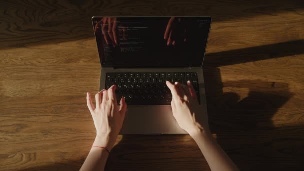 Widok z góry na białą kobietę wpisującą kod na laptopie w świetle słońca. — Wideo stockowe