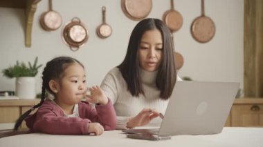 Annesi evde dizüstü bilgisayarıyla uğraşırken kızı eğleniyor.