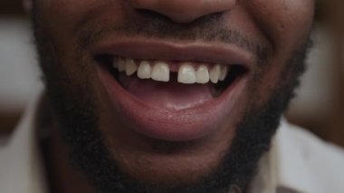 İçten bir gülümseme. Yetişkin bir Afro-Amerikalı 'nın gülüşü. Ağır çekimde, kapalı mekanda.