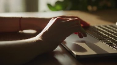 Kadın eli çekime giriyor ve ağır çekimde laptopun dokunmatik kısmında yana doğru kayıyor.