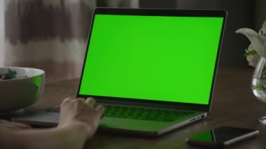 Kafkasyalı bir kadının, el kamerasında yeşil ekran krom anahtarı olan bir dizüstü bilgisayarın dokunmatik dokunmatik ekranında el dinlenme hareketini kapat.