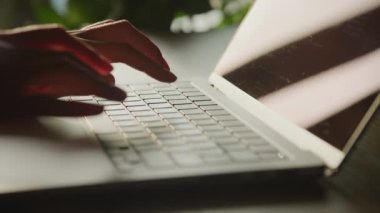Close up of caucasian woman hands typing coding on a laptop keyboard indoors in 90fps slow motion